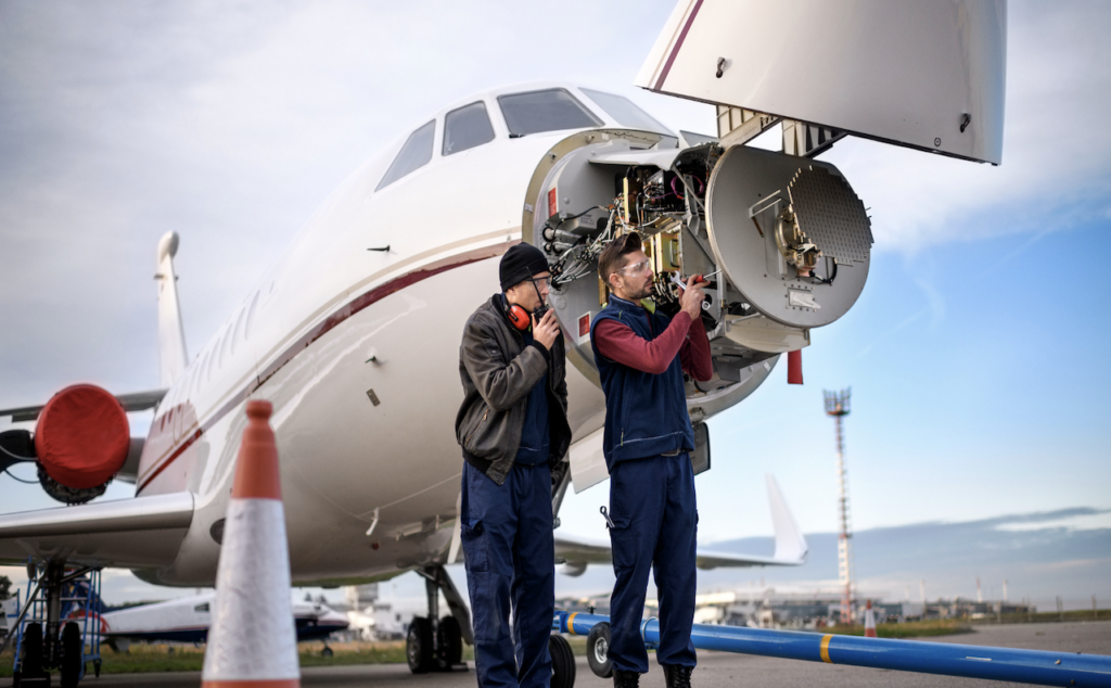 maintenance technician to Director of Maintenance DOM - two technicians working on nose of business jet